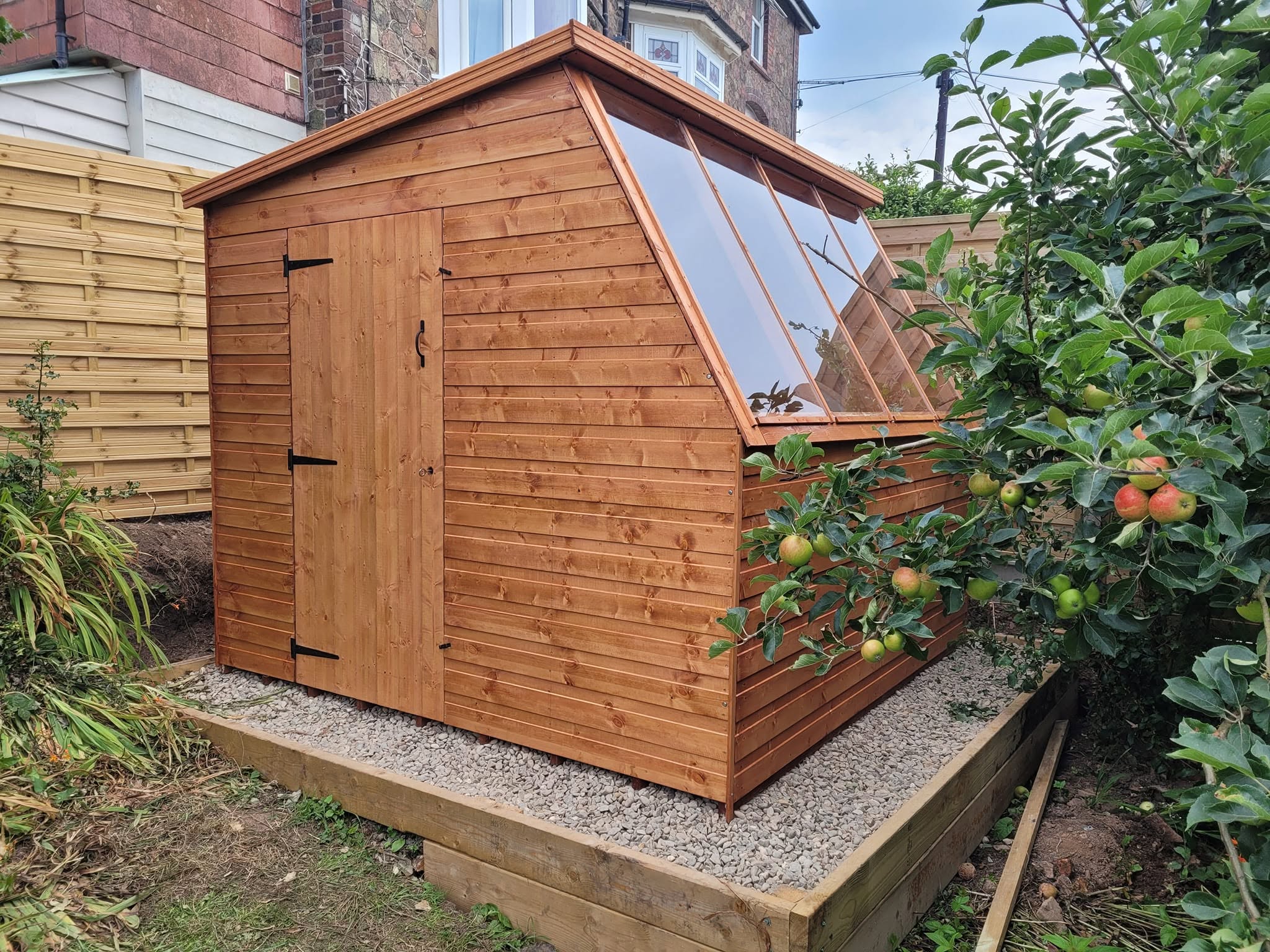 New timber potting shed with a glazed roof on a gravel and sleeper base