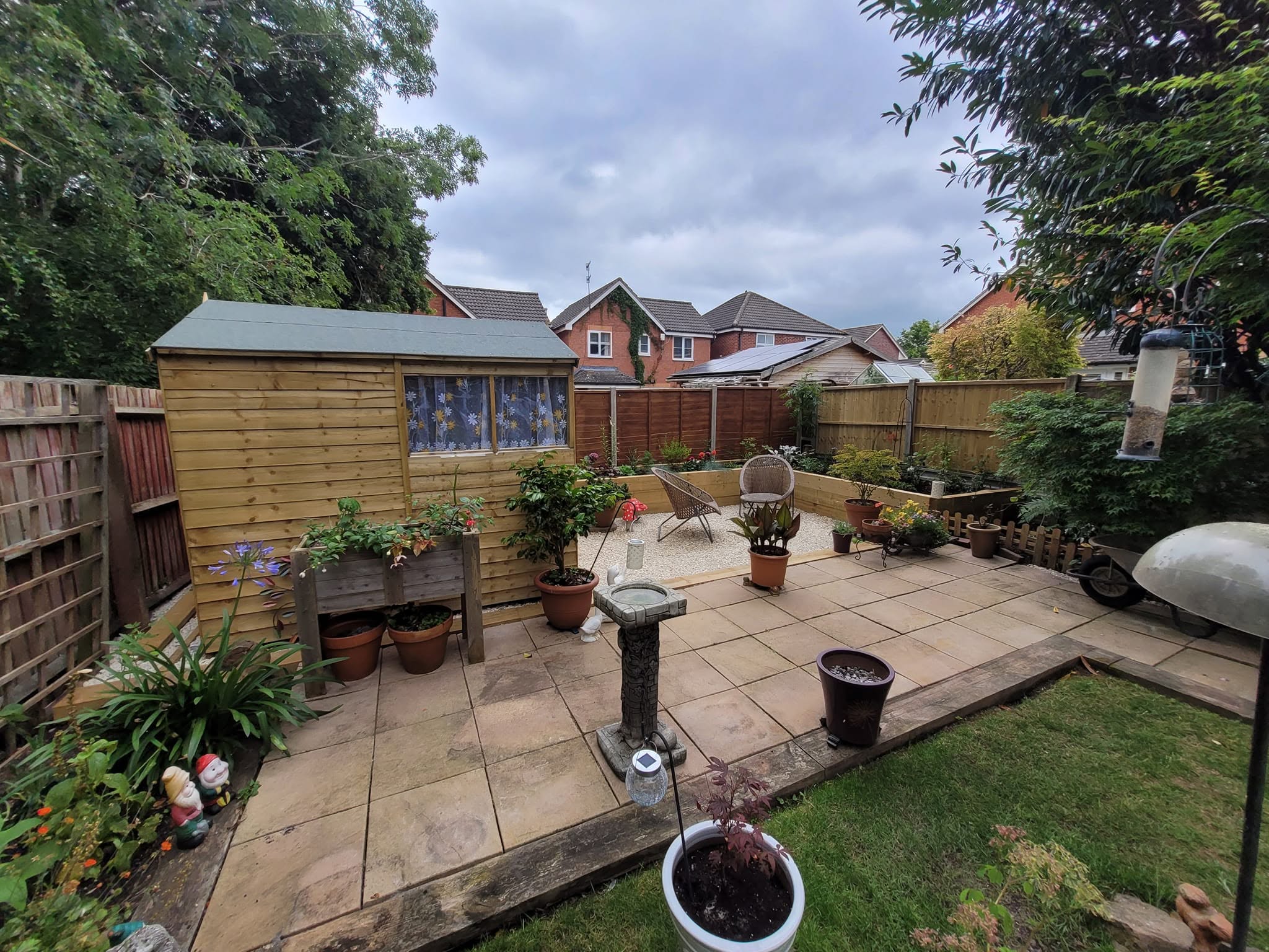 Patio edge, lawn and shed in a finished back garden