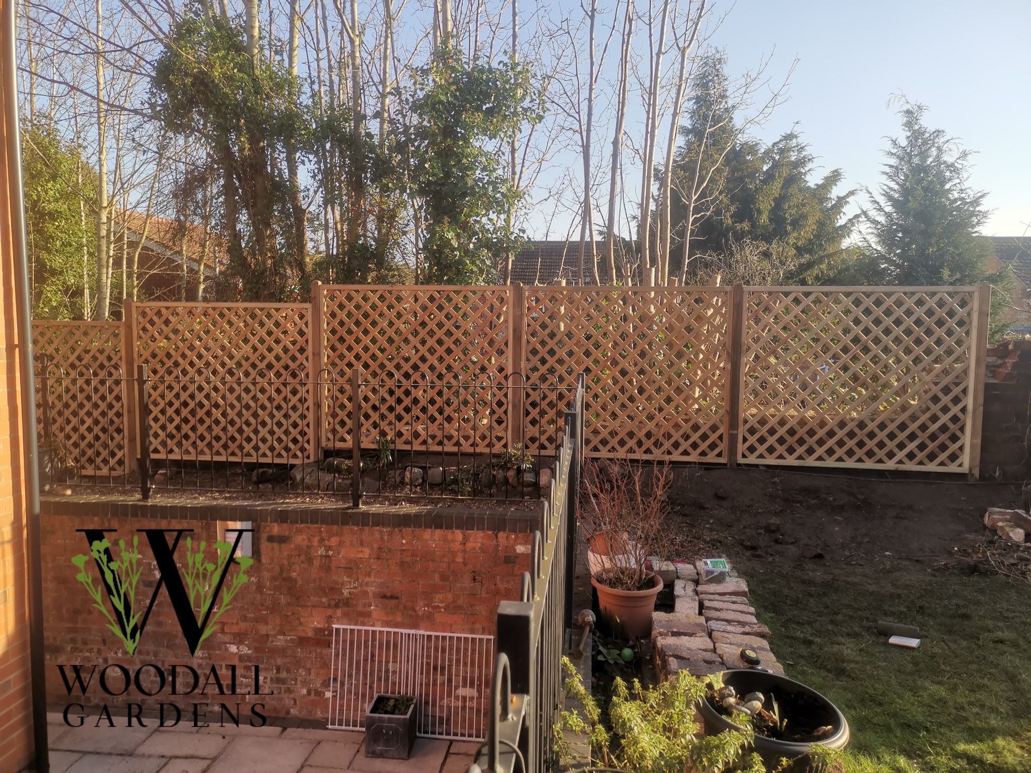 Trellis panels fitted above a brick garden wall